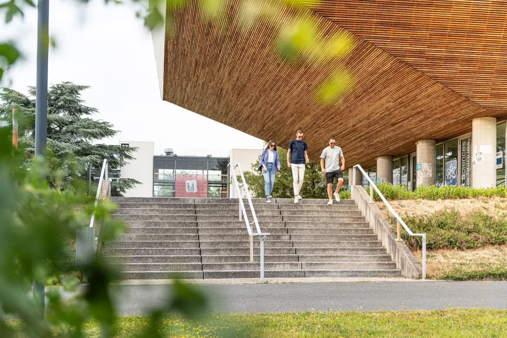 Trois étudiants descendant les escaliers de l'Université de Rouen